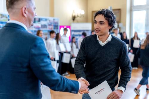 Z-ca Prezydenta wręczający stypendium zawodnikowi