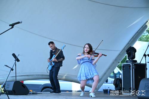 Na zdjęciu koncert Basi Kawy. Wokalistka śpiewa i gra na skrzypcach