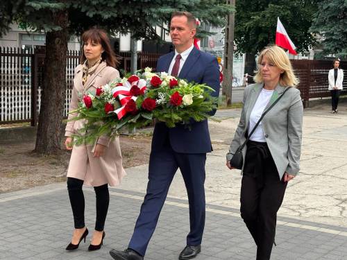 Delegacja władz miasta składa kwiaty pod Pomnikiem Nieznanego Żołnierza. Zastepca prezydentav w asyście sekretarz miasta i skarbniczki miasta niesie wiązankę biało-czerwonych kwiatów